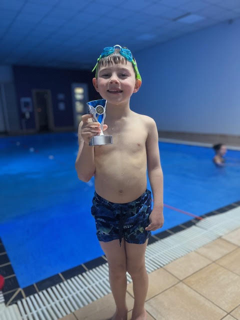 Isaac smiling with an instructor during a Duck N Dive session