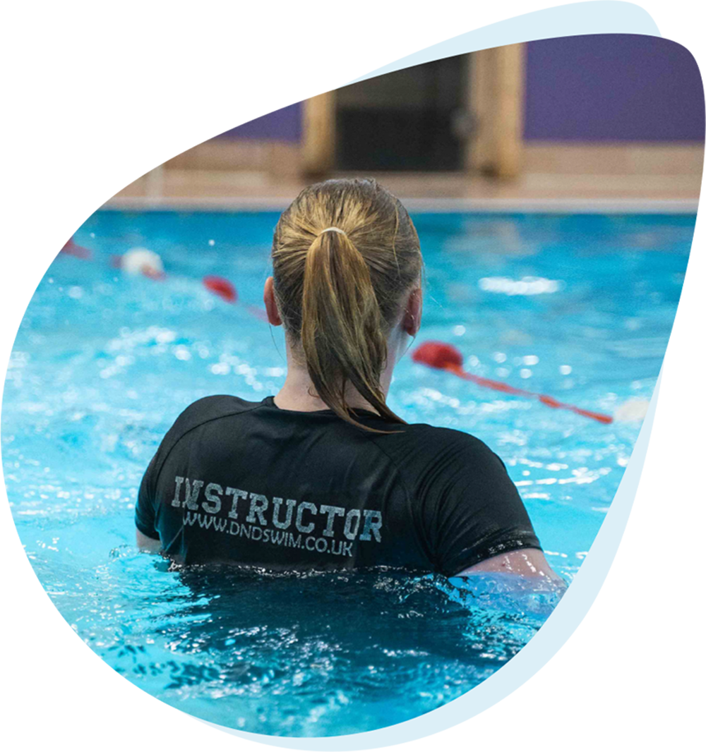 Instructor encouraging a young swimmer during lessons
